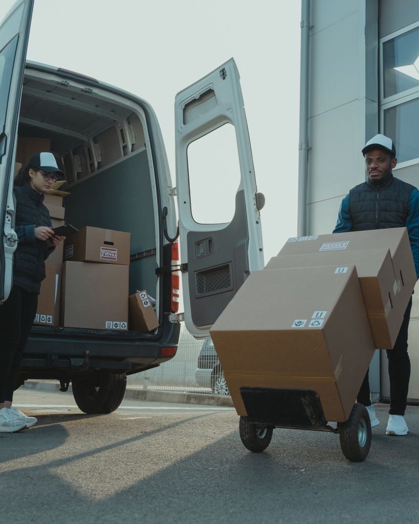 A man delivers and picks up boxes to and from the customer's house/apartment.
